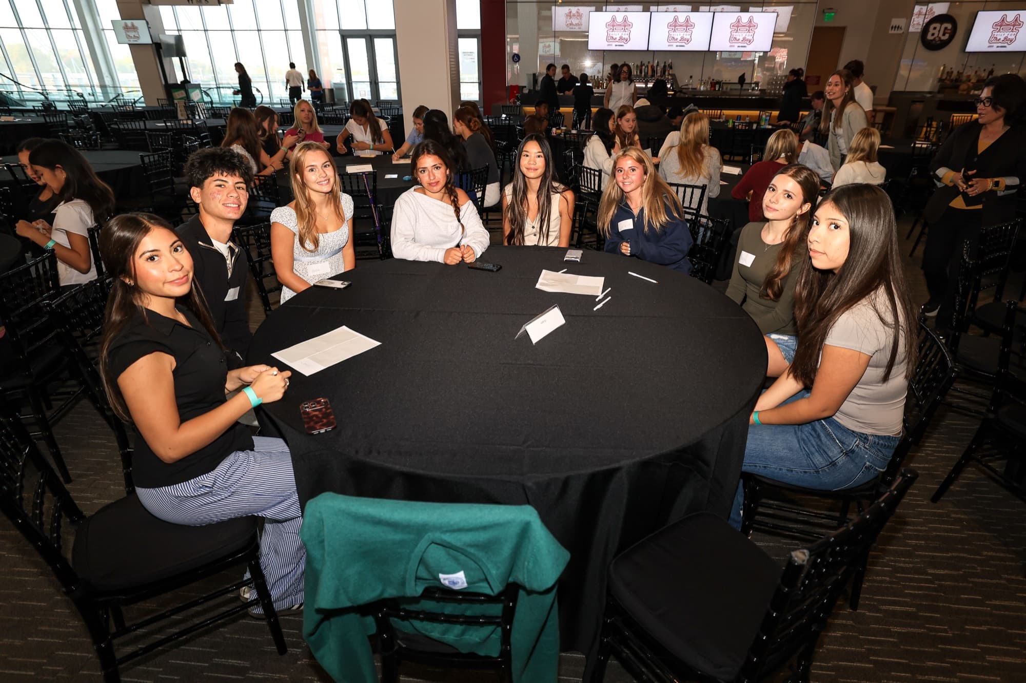 Bay Area high school students seated around a table at Built for the Bay in Levi's Stadium